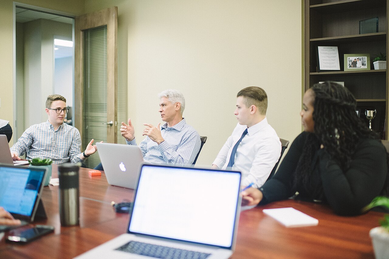 Four office workers seated around a table in a business meeting